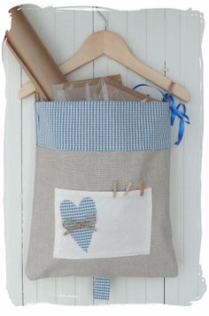 a blue and white quilt hanging on a wall next to a wooden hanger with two hearts