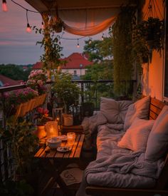 the balcony is lit up with candles and flowers on it, while the sun sets