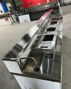 an automated conveyor belt with stainless steel trays and dividers on the side