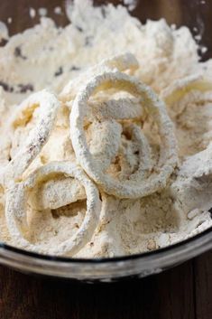 a bowl filled with powdered dough on top of a wooden table