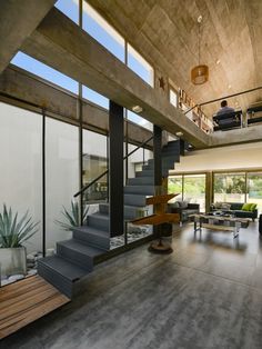 an open living room with stairs leading up to the second floor