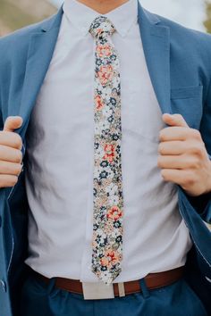 a man in a suit and tie is holding his jacket open