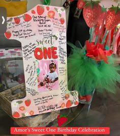 a birthday card with strawberries on it and a vase filled with flowers in the center