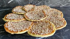 a pile of pastries sitting on top of a black marble counter topped with powdered sugar