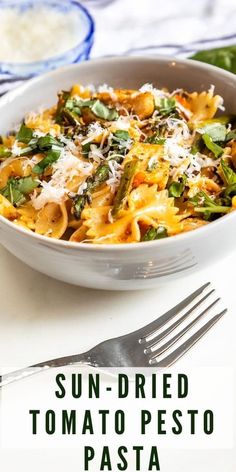 sun dried tomato pesto pasta with spinach and parmesan cheese in a white bowl