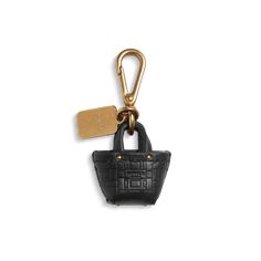 a small black purse with a gold keychain hanging from it's side