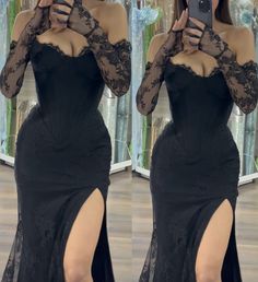 a woman taking a selfie wearing a black dress with long sleeves and thigh high slit