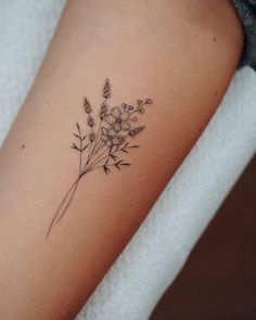 a woman's arm with a flower tattoo on the left side of her arm