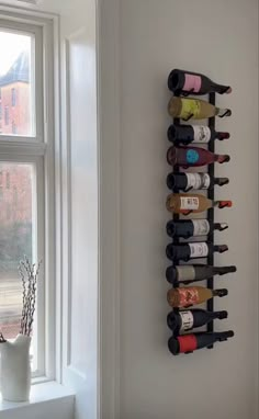 a wall mounted wine rack next to a window