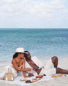 a man and woman sitting on the beach