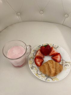 a plate with some strawberries on it next to a glass of milk