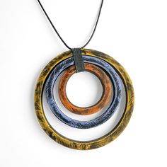 Polymer Clay Necklace - A trio of weathered polymer clay circles in shades of orange, yellow, and perwinkle are gathered with gray waxed linen thread and strung on an adjustable black nylon cord in this artful pendant which closes via a slider knot. Circle Jewelry Design, Polymer Clay Necklaces Ideas, Cold Play, Wire Projects, Metal Art Jewelry, Jewelry Ceramic, Pottery Jewelry, Earring Styles, Clay Things