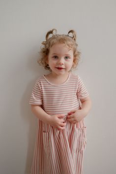 Let her twirl to her heart's content in this playful little Myra dress, reminiscent of sugar and all things sweet! Designed for maximum comfort and practicality, this classic striped dress with adorable front pockets will become a summer staple in her closet. Fit: runs a little small, so check the size chart and size up if in doubt Style: pull on knit dress in classic pink and white stripes with front pockets Color: pink and white Fabric content: 35% Rayon 60% Polyester 5% Spandex Care instructions: wash gentle cycle, cold; lay flat to dry, cool iron if needed. For best results, always follow care instructions on garment label. Our sizing is always approximate and can vary due to personal preference and style. For the best experience - and to make life easier for everyone! - please careful Striped Summer Dress For Playtime, Striped Spring Dresses For Playtime, Cute Striped Dress For Playtime, Playful Striped Short Sleeve Dress, Cute Striped Cotton Dress, Playful Striped Dresses For Playdate, Playful Striped Dress For Playdate, Striped Summer Dresses For Playdate, Striped Dresses For Summer Playdate