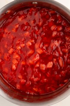 a pot filled with red sauce sitting on top of a stove