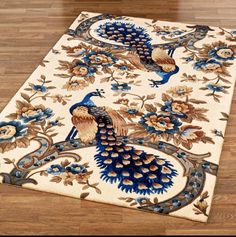 a rug with two peacocks on it in the middle of a wooden flooring area