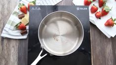 a pan sitting on top of a stove with strawberries