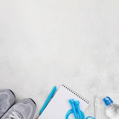 a pair of sneakers, notebook and water bottle on a white background with copy space