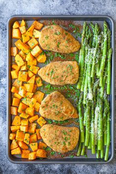 asparagus and sweet potatoes on a baking sheet