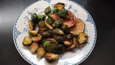 a white and blue plate topped with brussel sprouts on top of a table