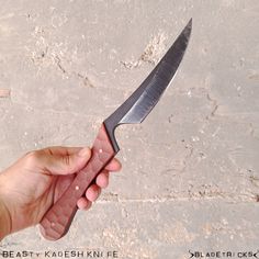 a person holding a large knife in their hand with the blade still attached to it