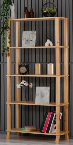 a wooden shelf with books and pictures on it in front of a black striped wall