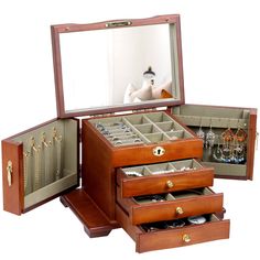 an open wooden jewelry box with three drawers and several pairs of earrings in the bottom drawer