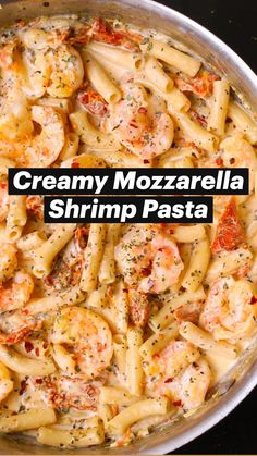 a pan filled with pasta and shrimp on top of a stove