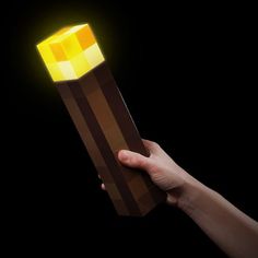 a hand holding an object with a glowing light on it