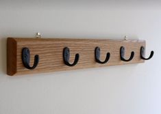 three coat hooks are mounted on a wall