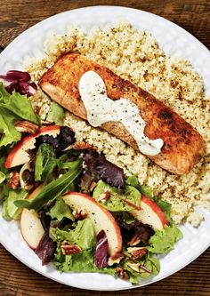 a white plate topped with meat, rice and salad