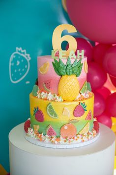 a birthday cake decorated with pineapples and fruit