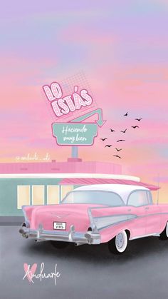 an old pink car is parked in front of a building with birds flying around it