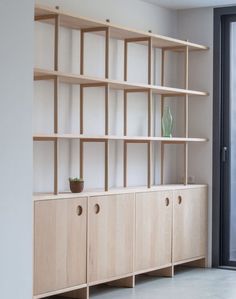 an empty room with wooden shelves and vases on the shelf next to each other