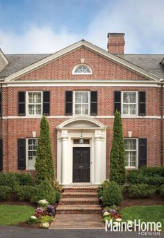 a large brick house with black shutters and white trim