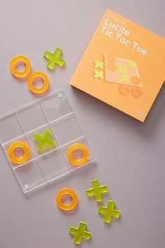 an orange and yellow game set next to it's instructions for tic - tac toe