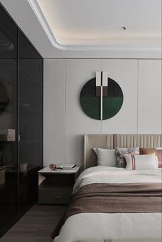 a large bed sitting under a round mirror on the wall next to a night stand