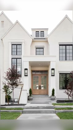 a large white house with two story windows and steps leading up to the front door