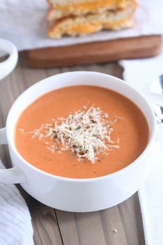 a bowl of tomato soup with cheese on top