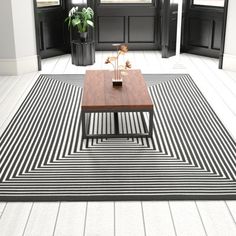 a black and white striped rug with a coffee table in the middle on top of it