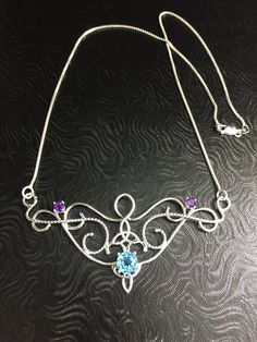 I love Victorian and Renaissance style statement necklaces with a magical and timeless flair, and I hope I've captured it within this piece! I shall fabricate for you this gorgeous Elvish/Renaissance style necklace, in sterling silver, with a center 8mm Blue Topaz and two side 4mm Amethyst gemstones. The center gemstone is 8mm round and the two sides are 4mm round. The chain will be soldered to each side and I will use a 1.2mm thick sterling box chain with a lobster claw clasp for added straight Spiritual Necklace With Sterling Silver Clasp As Gift, Artisan Birthstone Necklace For Gifts, Unique Sterling Silver Necklace Gift For Her, Artisan Necklace With Sterling Silver Clasp, Bohemian Necklace With Sterling Silver Clasp, Bohemian Necklace With Sterling Silver Clasp For Gift, Artisan Necklace With Sterling Silver Clasp For Gift, Silver Bohemian Birthstone Necklace, Bohemian Jewelry With Sterling Silver Clasp As Gift