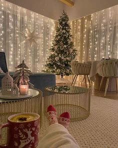 a person laying on the floor with their feet up next to a christmas tree in a living room