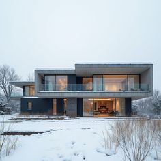 a modern house in the winter with snow on the ground