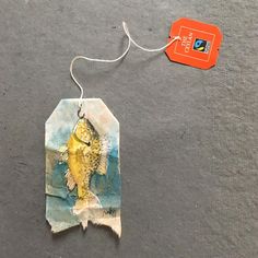 a piece of torn paper with a fish on it and a tag attached to it