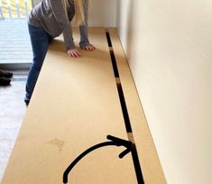 a woman standing on top of a wooden table next to a wall with an arrow drawn on it