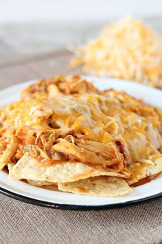 a white plate topped with chicken nachos covered in cheese