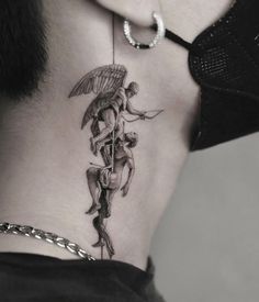 the back of a woman's neck with an angel and devil tattoo on it