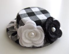 a black and white checkered hat with a flower on the side, sitting on a table