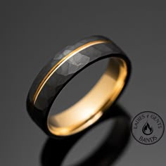 a wedding ring with gold inlays and a black diamond pattern on the inside