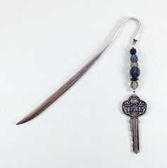 a pair of scissors and some beads on a white table with a keychain