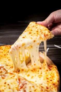 a slice of cheese pizza being lifted with a wooden spatula